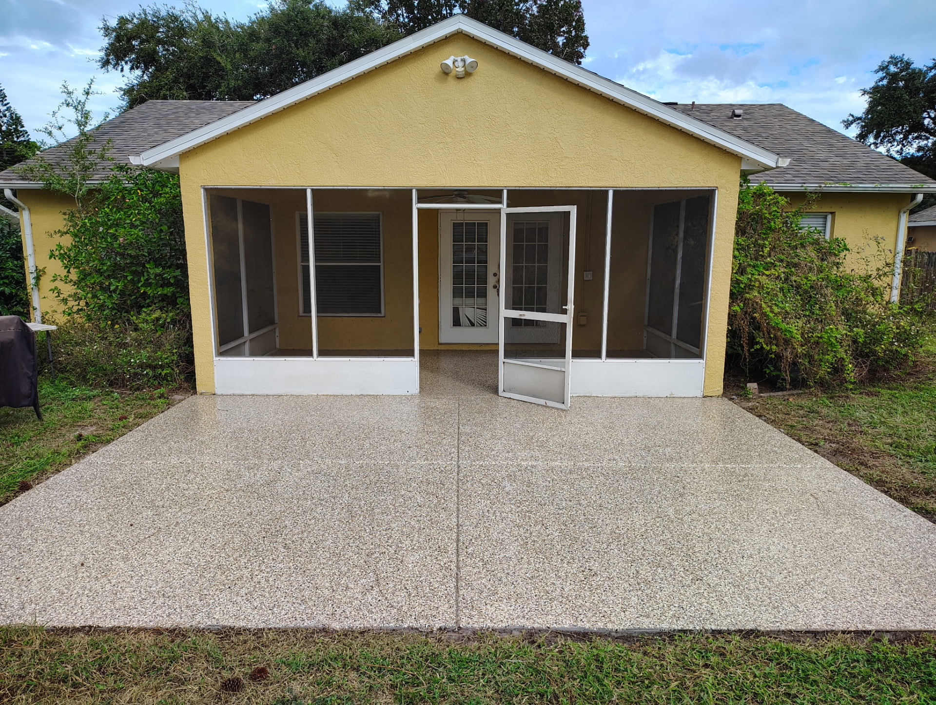Tan and brown full-broadcast flake epoxy coating on a back patio in Port St. John, FL