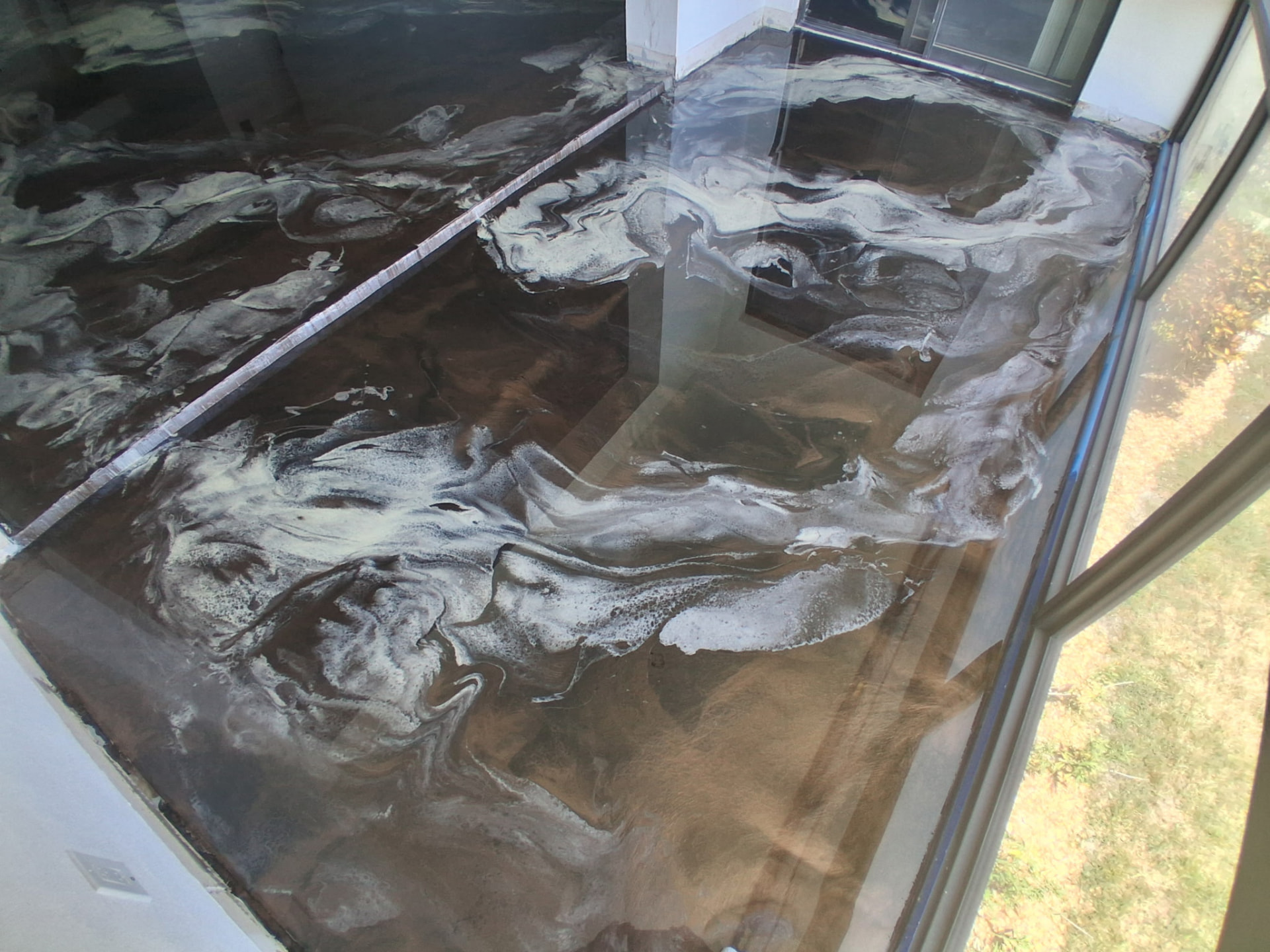 Second-angle view of the marble-style metallic epoxy floor in a Cocoa Beach sunroom