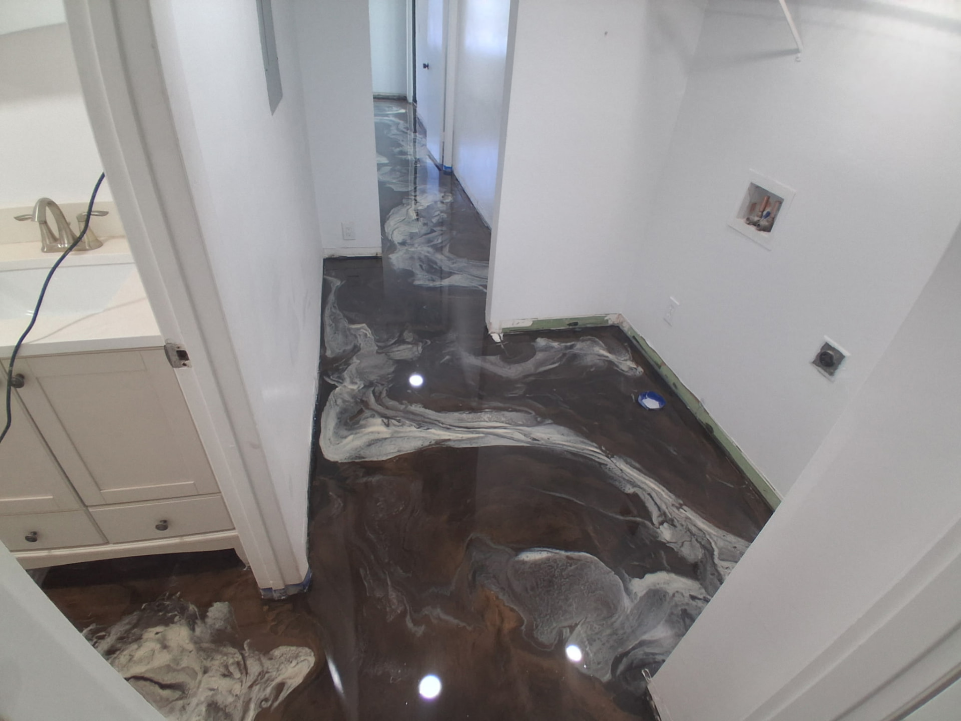 Brown and pearl metallic epoxy floor spanning a condo laundry room and hallway in Cocoa Beach